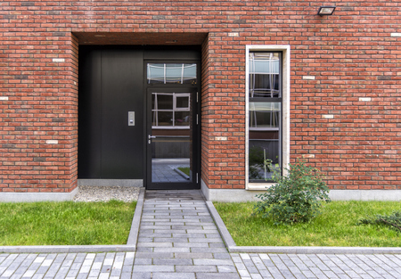 The entrance to the store. Glass door in the house in loft style. Red brick house. The lawn in front of the house.の写真素材