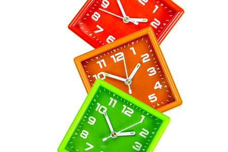 Three bright alarm clocks on a white background. Clokcs green, orange and red.の写真素材