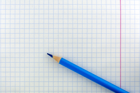 Sheet school notebook in a cage. The pencil is blue on the sheet.の写真素材