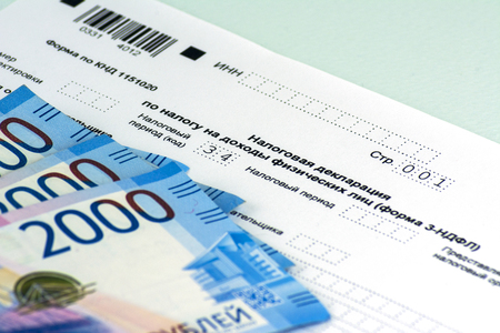 Russian annual tax Declaration of taxes of individuals. The Form 3-NDFL. A few Russian notes are on the sheet of the Declaration. Blue background.の写真素材