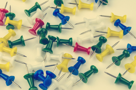 Colorful pushpin pointers loose lie on paper. Soft handling in old vintage styleの写真素材