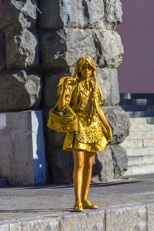 Kiev, Ukraine, 07 august 2018. Girl depicting a statue on a city street. A living statue painted in gold on the street.のeditorial素材