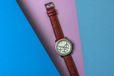 Women's fashion wrist watch on purple background. The blue sheet soars above the main purple background.の写真素材