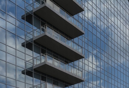 Reflection of the sky and clouds in the Windows of a multi-storey glass building