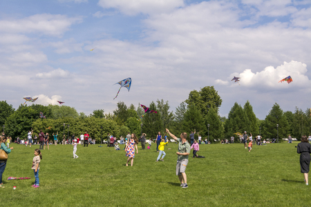 Moscow. Russia. 26 may 2019. People relax on a large lawn in the Park Tsaritsyno. Launch into the sky colorful kitesのeditorial素材