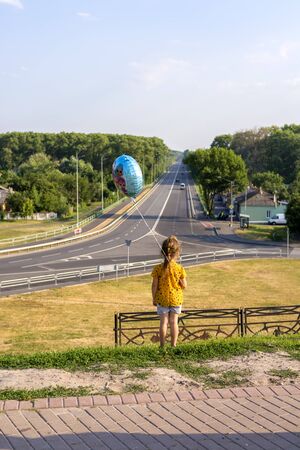 Chernihiv, Ukraine, 22 June 2019. The girl with the balloon looks at the road going awayのeditorial素材