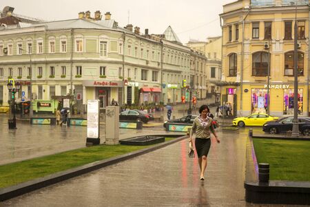 Moscow, Russia, July 17, 2019. Summer rain in Moscow, a woman without an umbrella walking down the street.のeditorial素材