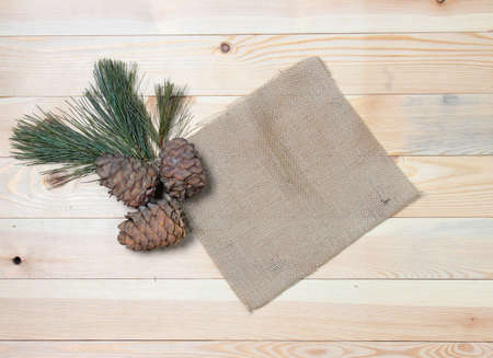The cedar branch with cones on vintage fabrics on a wooden textureの写真素材