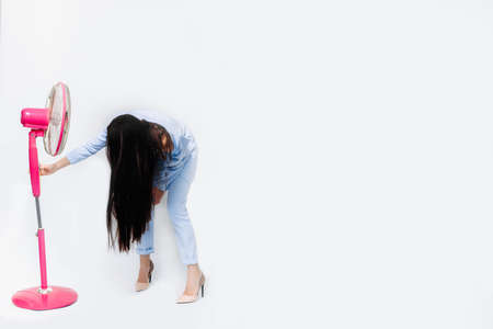 Use the fan in the office struggle with the lack of air conditioning . Isolated on a white background.の写真素材