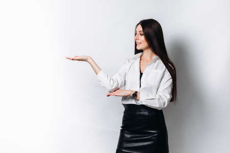 Young beautiful brunette businesswoman smiling looking at camera pointing finger in side over white background.の写真素材