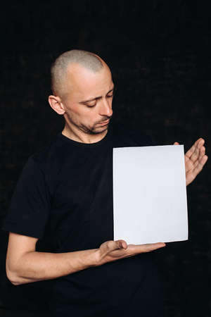 young man with an empty white banner. A person holds an advertising sheet, a copy space, isolatedの写真素材