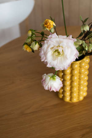 Bouquet in a yellow ceramic designer vase. It's on the table . Lifestyle flowers on the kitchen...