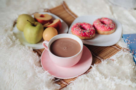 simple Breakfast in bed, pink Cup of cocoa and pink doughnut, sliced fruit, Apple,apricot.の写真素材