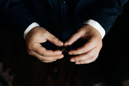 Groom holding wedding rings on the palm, wedding ring in groom hand.の写真素材