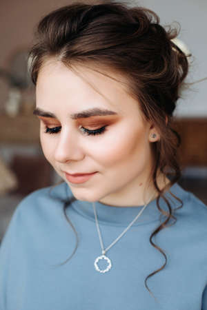 portrait of a beautiful girl , collected hairstyle and gentle makeup. Eyes look down, red shadows on the eyes.の写真素材