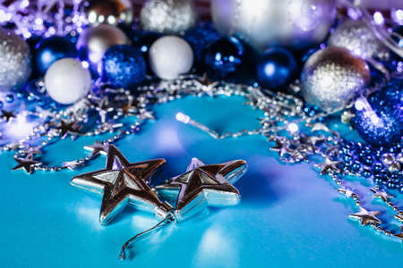 Silver stars in the foreground,a garland and Christmas balls on a turquoise background.の写真素材