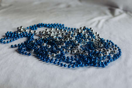 Christmas tree beads in blue and silver on a white background.の写真素材