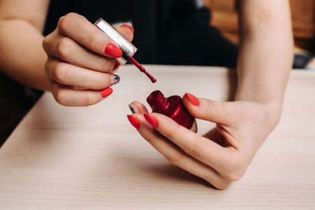 Woman applying nail polish on her manicured nail carefully