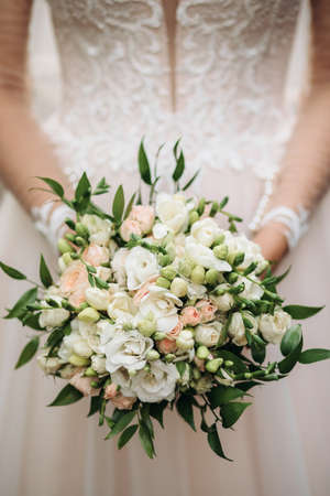 Bride holds a beautiful, gentle wedding bouquet of flowersの写真素材