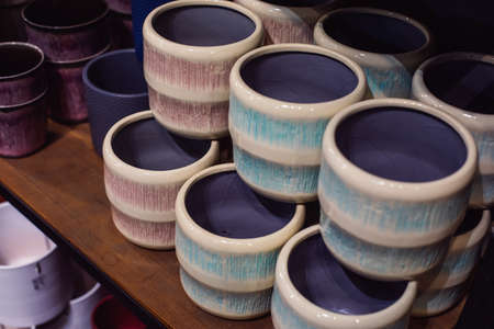 colorful empty flower pots stand on a shelf in the store