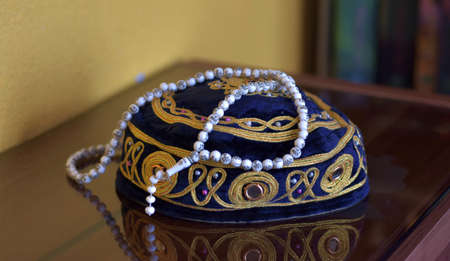 Islamic muslim prayer cap and beads necklace rosemary isolated on reflective backgroundの写真素材