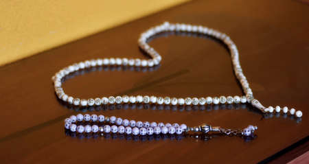 Islamic muslim prayer beads rosemary in a shape of heart isolated on reflective backgroundの写真素材