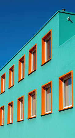 Colorful facade of a modern apartment building with windows and balconiesの素材