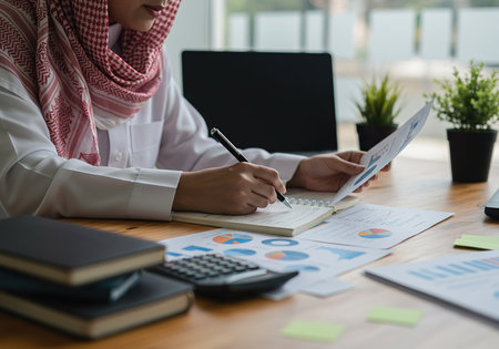 Hijab businesswoman working with calculator and laptop in office. Accountingの素材