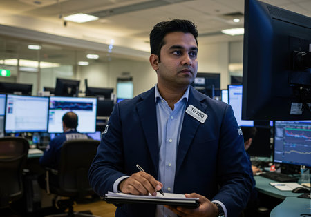 Portrait of security guard writing on clipboard in surveillance room of officeの素材