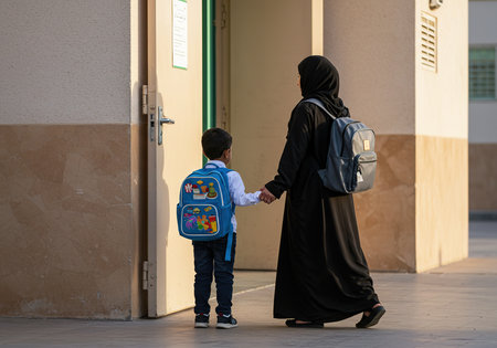 Muslim mother and son with backpacks going to school in the morningの素材