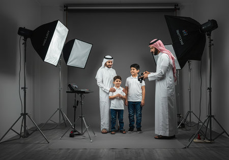 Arabic man and his son posing in photo studio with professional equipmentの素材