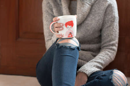 cup of chamomile, woman drinking cup of tea or coffee on wooden backgroundの写真素材