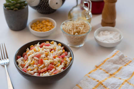 Pasta salad with yogurt and tomato sauce, corn and green onion on white backgroundの写真素材