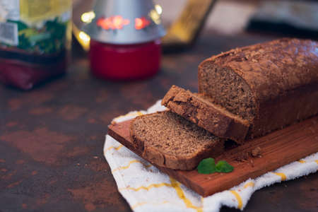 Chocolate cake with coconut essence and a mint leaf on wooden table.