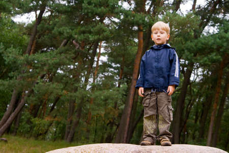 portrait of a little boy standing in the forestの写真素材