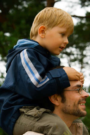smiling father carrying his little son on his shouldersの写真素材