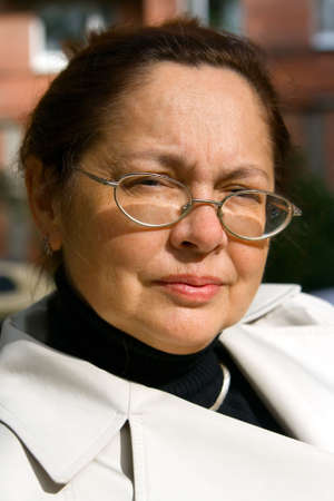 portrait of a senior woman in glasses, with candid smile
