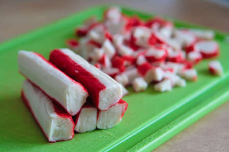 close-up green plate with red crab sticks - cut and not cutの写真素材