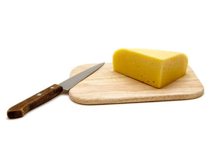 block of cheese on cutting board with a knife, isolated on white backgroundの写真素材