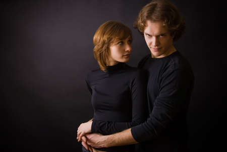 portrait of a couple: woman is looking on a man, man is looking straight
