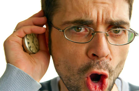 man in glasses with opened mouth, he is listening to ticking of his clock, isolated on white...