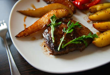 close-up fried steak with arugula, served with baked potatoes, paprika and pearの写真素材