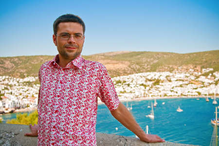 portrait of a smiling man standing in front of the sea bayの写真素材