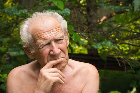 portrait of a pensive senior man holding his hand near his faceの写真素材