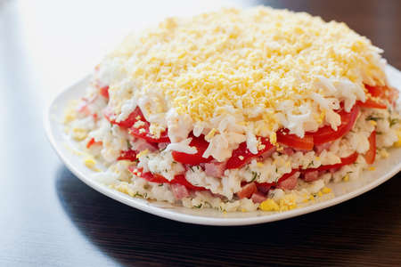 close-up salad made with layers of rice, tomatoes, sausage, cheese and eggsの写真素材