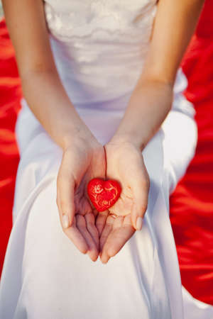 newlywed woman holding in her hands red heart - symbol of loveの写真素材