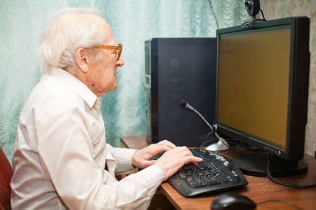 portrait of a senior man typing something on his computer