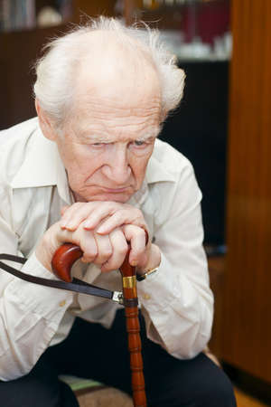 unhappy old man holding his caneの写真素材