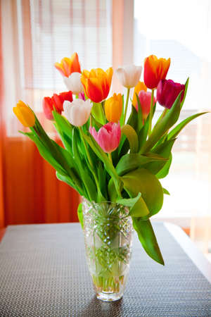 a big bouquet of tulips of various colours in a vaseの写真素材