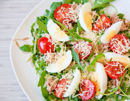 close-up salad with arugula, eggs, tuna, tomato and parmesanの写真素材